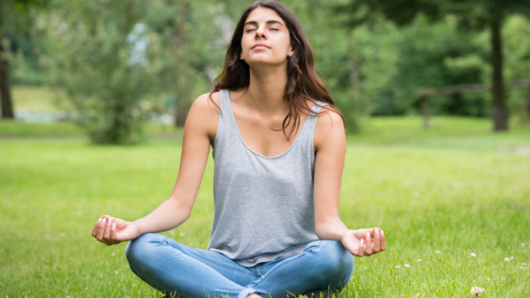 Woman Doing Meditation In Park