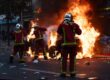 Feuerwehrleute löschen ein brennendes Auto in Paris